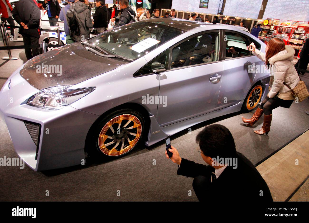 Visitors take photos of a Toyota Motor Corp.'s hybrid car "Prius" Custom Concept Plus on display during the Tokyo Auto Salon 2010 customized car exhibition at Makuhari Messe in Chiba, east of Tokyo, Japan, Friday, Jan. 15, 2010. (AP Photo/Itsuo Inouye) Stockfoto