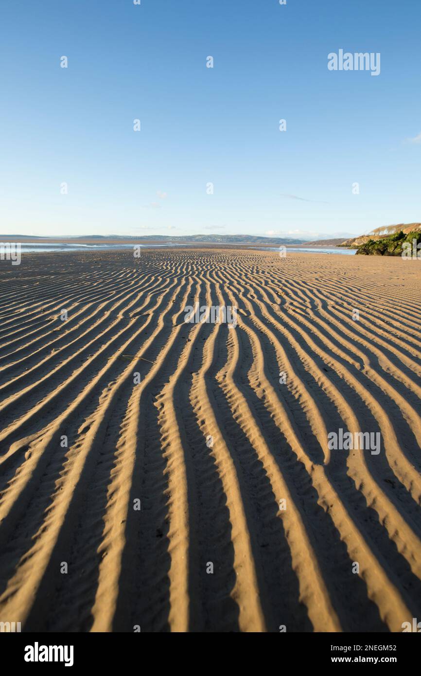 Wellen, die bei Ebbe am Punkt von Jenny Brown in der Nähe des Dorfes Silverdale im Sand zurückblieben. Morecambe Bay ist bekannt für seine Sonnenuntergänge, Salzmarschen und Shink Stockfoto