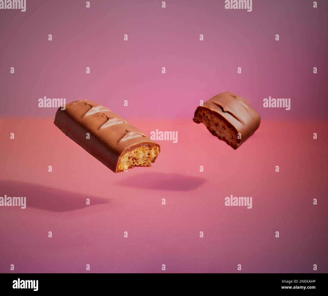 Ein Stück Schokolade schwebt in der Luft mit einem Schatten darunter und einem schönen abgestuften Hintergrund. Stockfoto