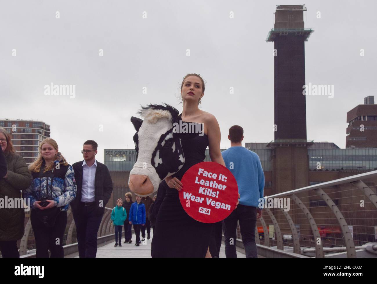 London, Großbritannien. 16. Februar 2023 PETA inszenierte am Vorabend der London Fashion Week einen „Laufsteg“ auf der Millennium Bridge mit einem Modell, das einen künstlichen Kuhkopf im Schiaparelli-Stil trug. Der Stunt soll die Menschen dazu inspirieren, Tierleder loszuwerden, und verweist auf Schiaparellis „Tierköpfe“, die kürzlich auf der Pariser Modewoche viel Kontroversen ausgelöst haben. Stockfoto