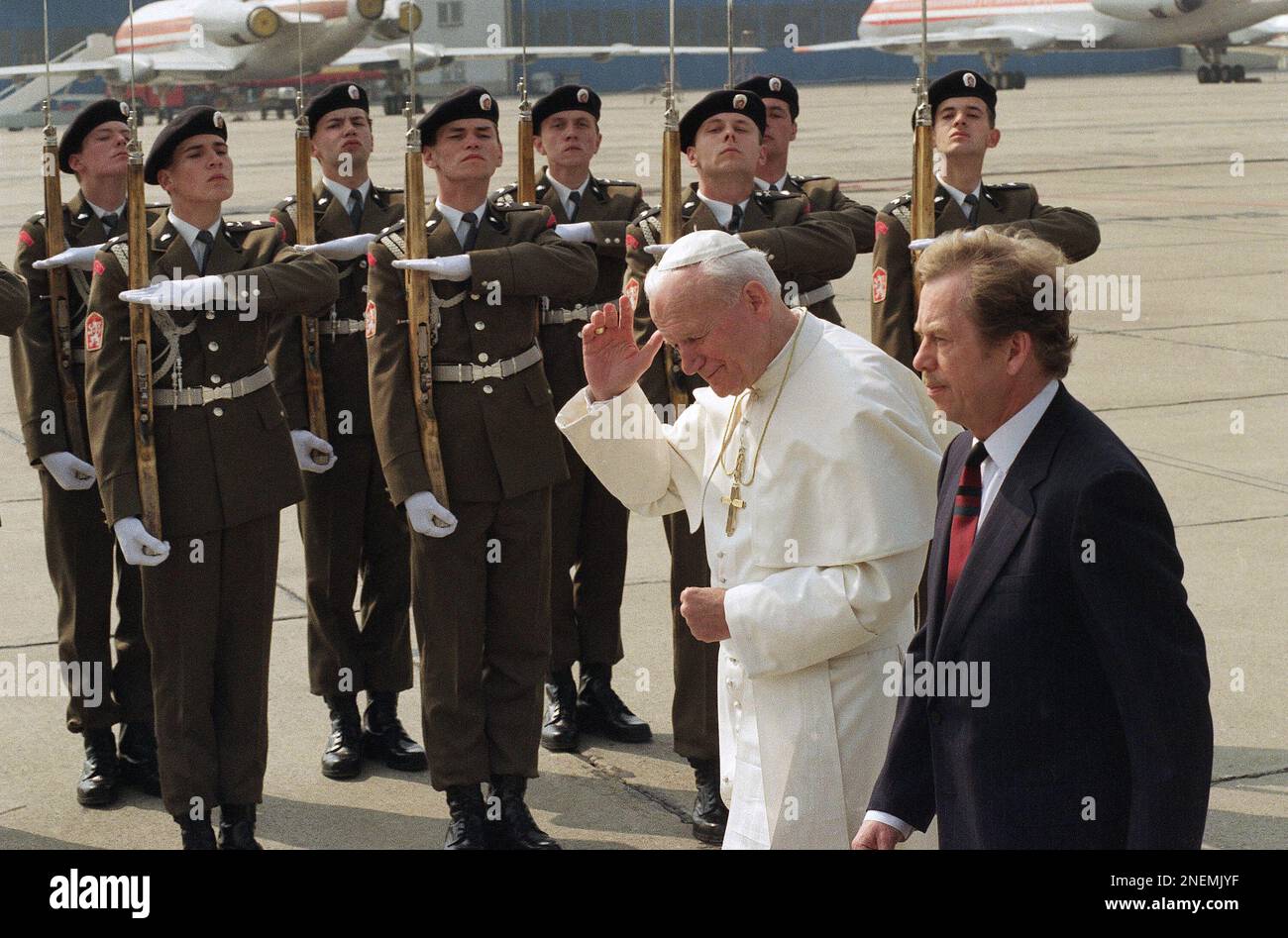 Pope John Paul II tries to hold his cap as he with dissident-turned Czechoslovak President Vaclav Havel, foreground, reviews the honor guard at the Prague Airport on Saturday, April 21, 1990 in Prague. The Pops spends two days in Czechoslovakia, the first Warsaw-pact country ? except his homeland Poland ? he visits. (AP Photo/Kurt Strumpf) Stockfoto
