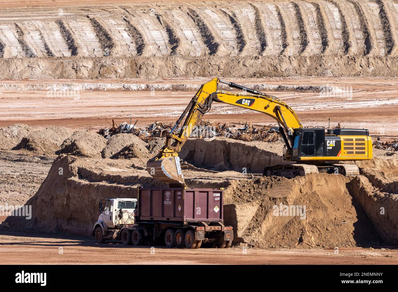 Ein HD-Hydraulikbagger beladen einen Containerwagen mit gefährlichen Uranbergwerken im UMTRA-Sanierungsprojekt in Moab, Utah. Stockfoto