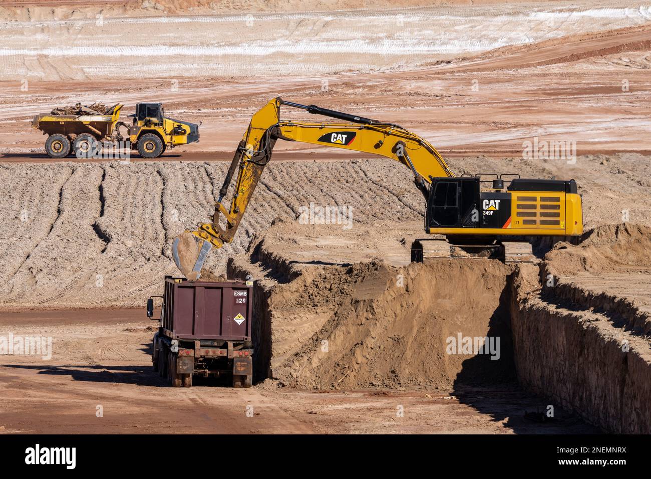 Ein HD-Hydraulikbagger beladen einen Containerwagen mit gefährlichen Uranbergwerken im UMTRA-Sanierungsprojekt in Moab, Utah. Stockfoto