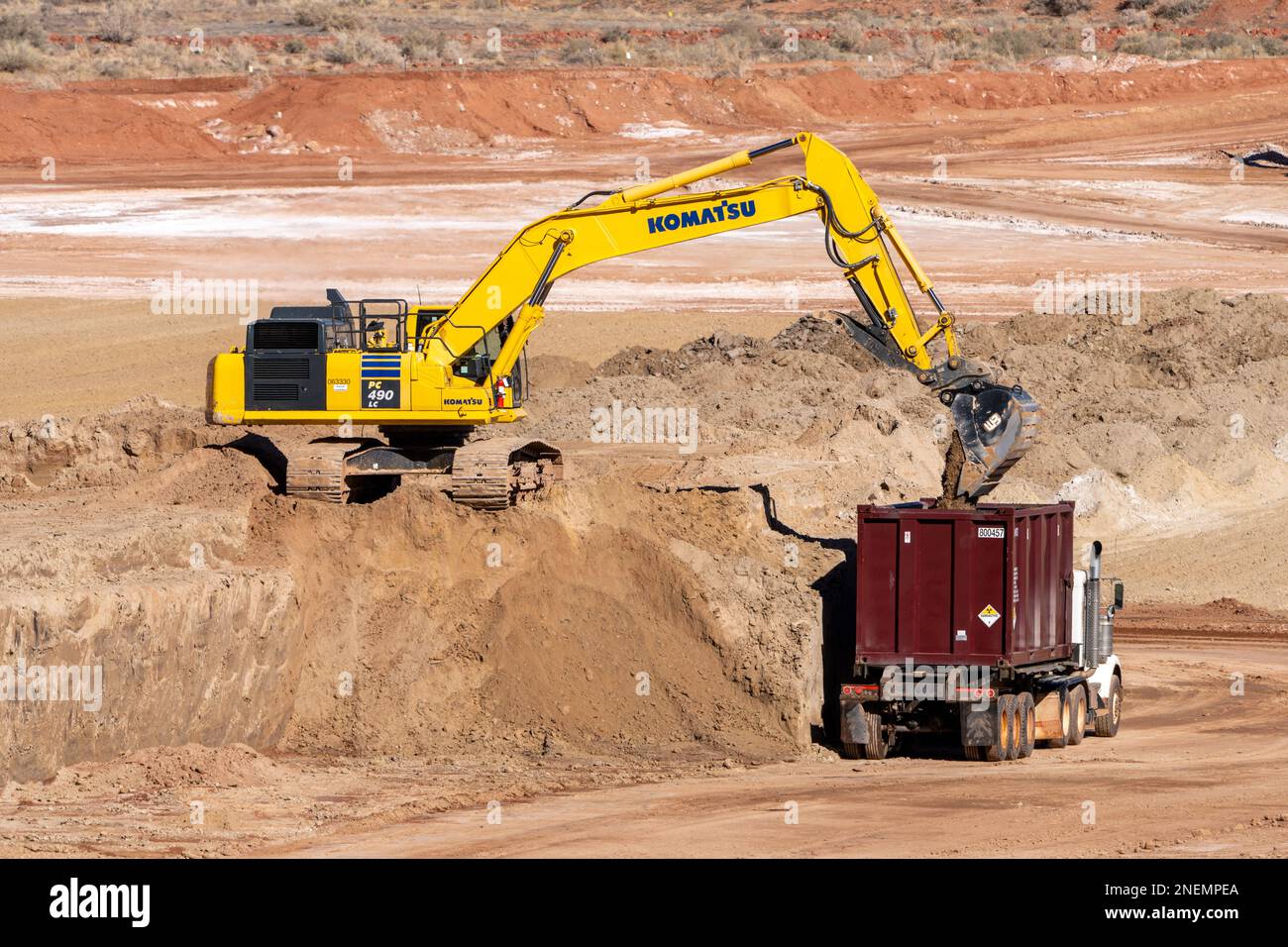 Ein HD-Hydraulikbagger beladen einen Containerwagen mit gefährlichen Uranbergwerken im UMTRA-Sanierungsprojekt in Moab, Utah. Stockfoto