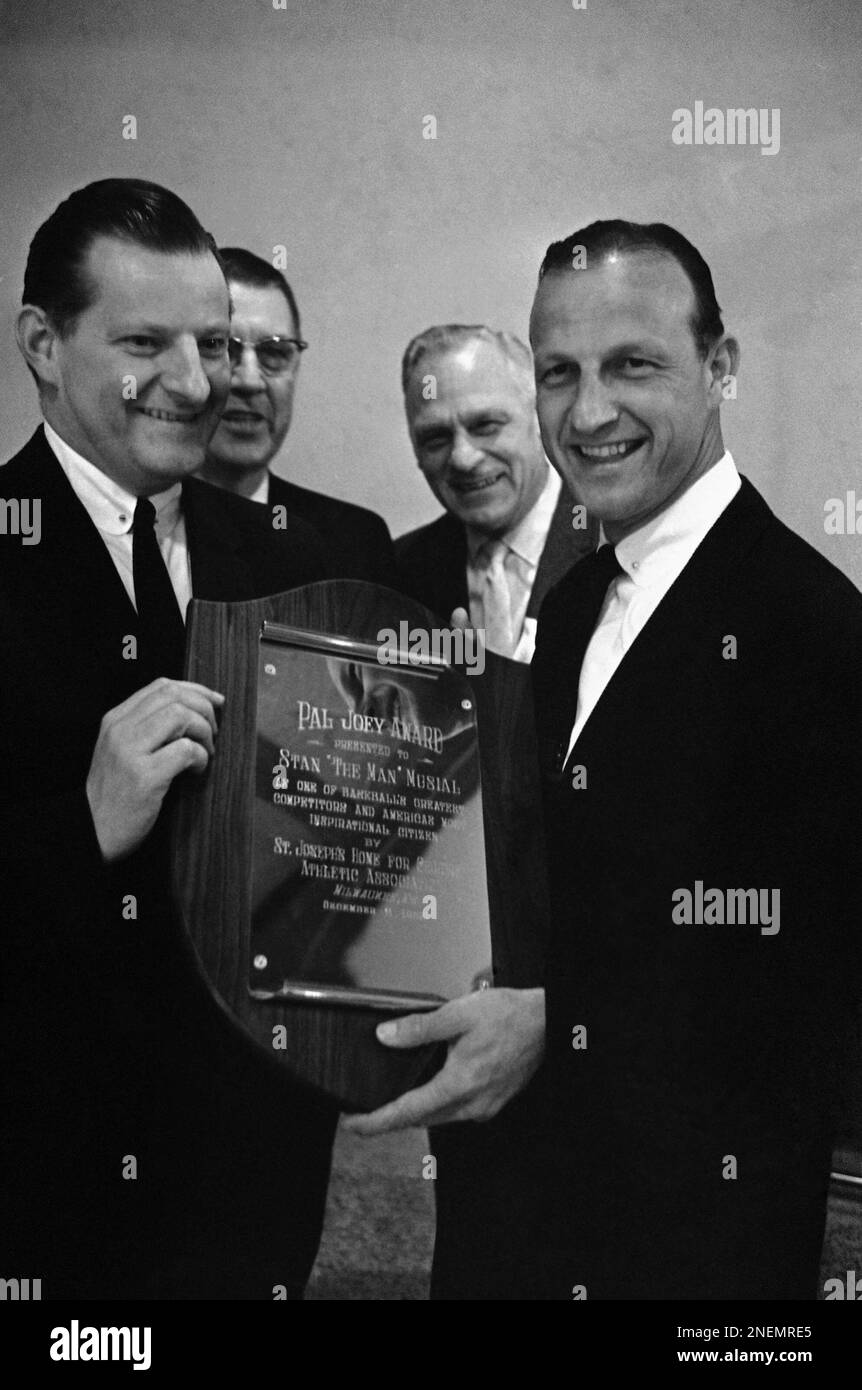 Stan Musial of the St. Louis Cardinals received the Pal Joey Award for his ?inspiration and example to youth,? Dec. 11, 1962 in Milwaukee. It was presented by Judge Robert C. Cannon, left, counsel for major league players. Watching the presentation are Lefty Gomez, left center, a speaker on the program and Charles Gillett, right center, president of Milwaukee?s St. Joseph Home for Children Athletic Association which sponsored the award. (AP Photo/Charles Knoblock) Stockfoto