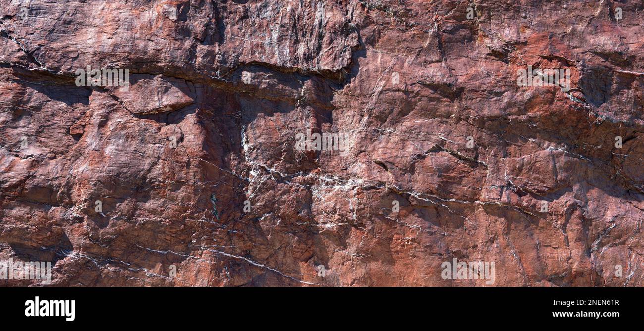 Grobe Oberfläche eines rot-braunen Gesteins in Nahaufnahme Stockfoto