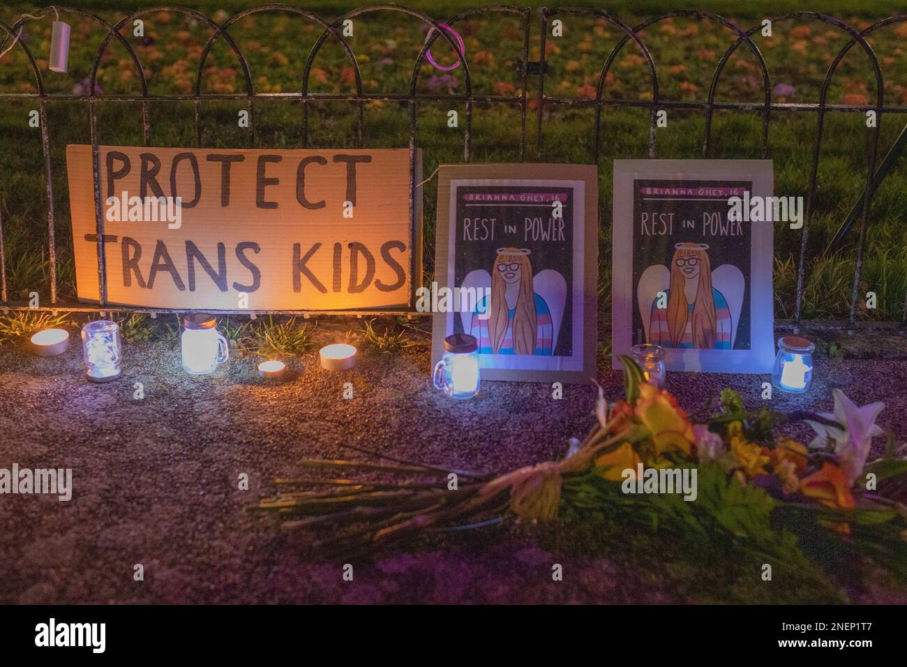 Southend on Sea, Großbritannien. Februar 2023. Eine feierliche Gedenkstätte in Southend mit Kerzen, Blumen und Schildern mit der Aufschrift „PROTECT TRANS KIDS“ und „REST IN POWER“. Die Tribute ehrt das Leben von Transgender und setzt sich für Jugendschutz ein, vor einem Metallzaun mit warmer Beleuchtung. Die Bewohner kommen zu einer Mahnwache für Brianna Ghey zusammen, die am Samstag, den 11. Februar, in Warrington Park, Cheshire, brutal ermordet wurde. Die Mahnwache findet in den Prittlewell Gardens statt. Penelope Barritt/Alamy Live News Stockfoto