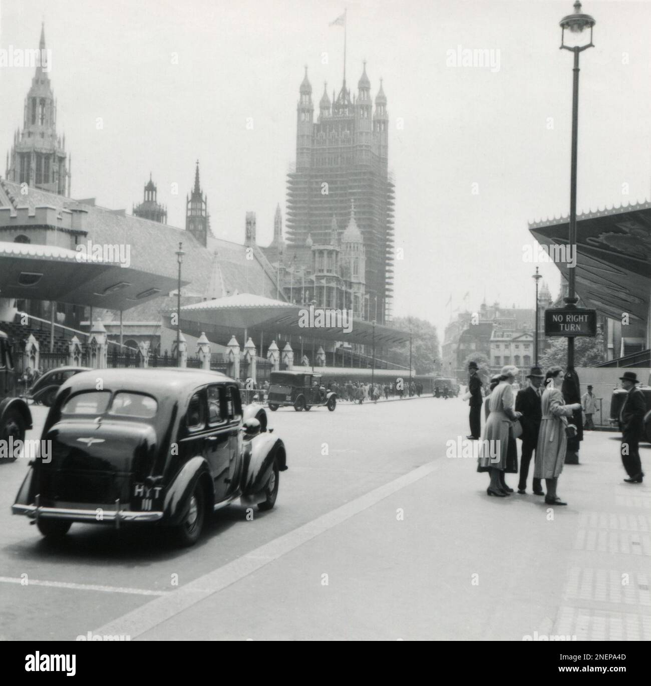 London, England. 1953. Blick von der Parliament Street auf die Houses of Parliament und den Victoria Tower. Entlang der Straße befinden sich temporäre Stände, die speziell für die Krönung von Königin Elizabeth II. Am 2. Juni 1953 errichtet wurden. Stockfoto