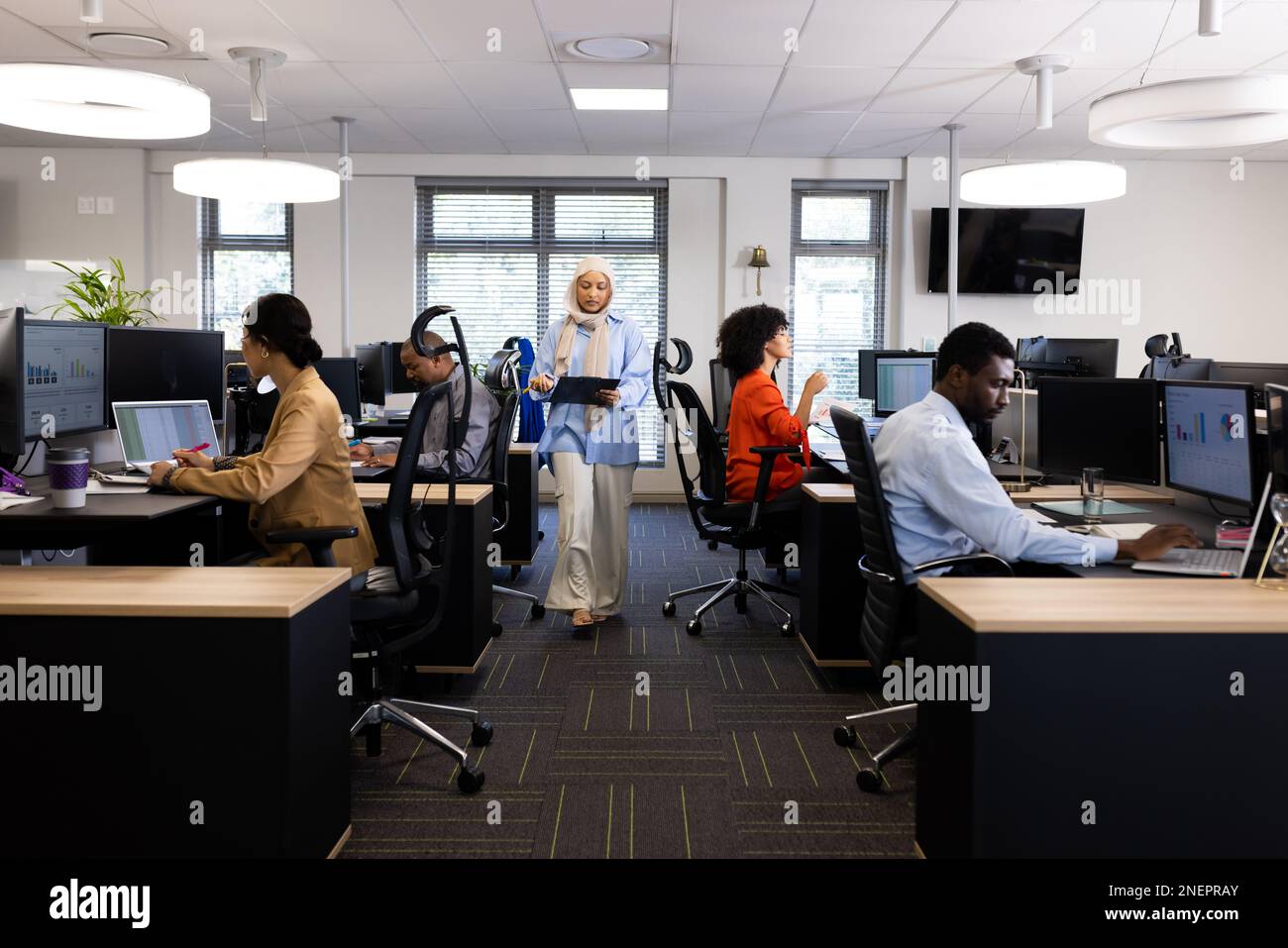 Vielfältige weibliche und männliche Geschäftsleute, die in einem offenen Büro arbeiten Stockfoto