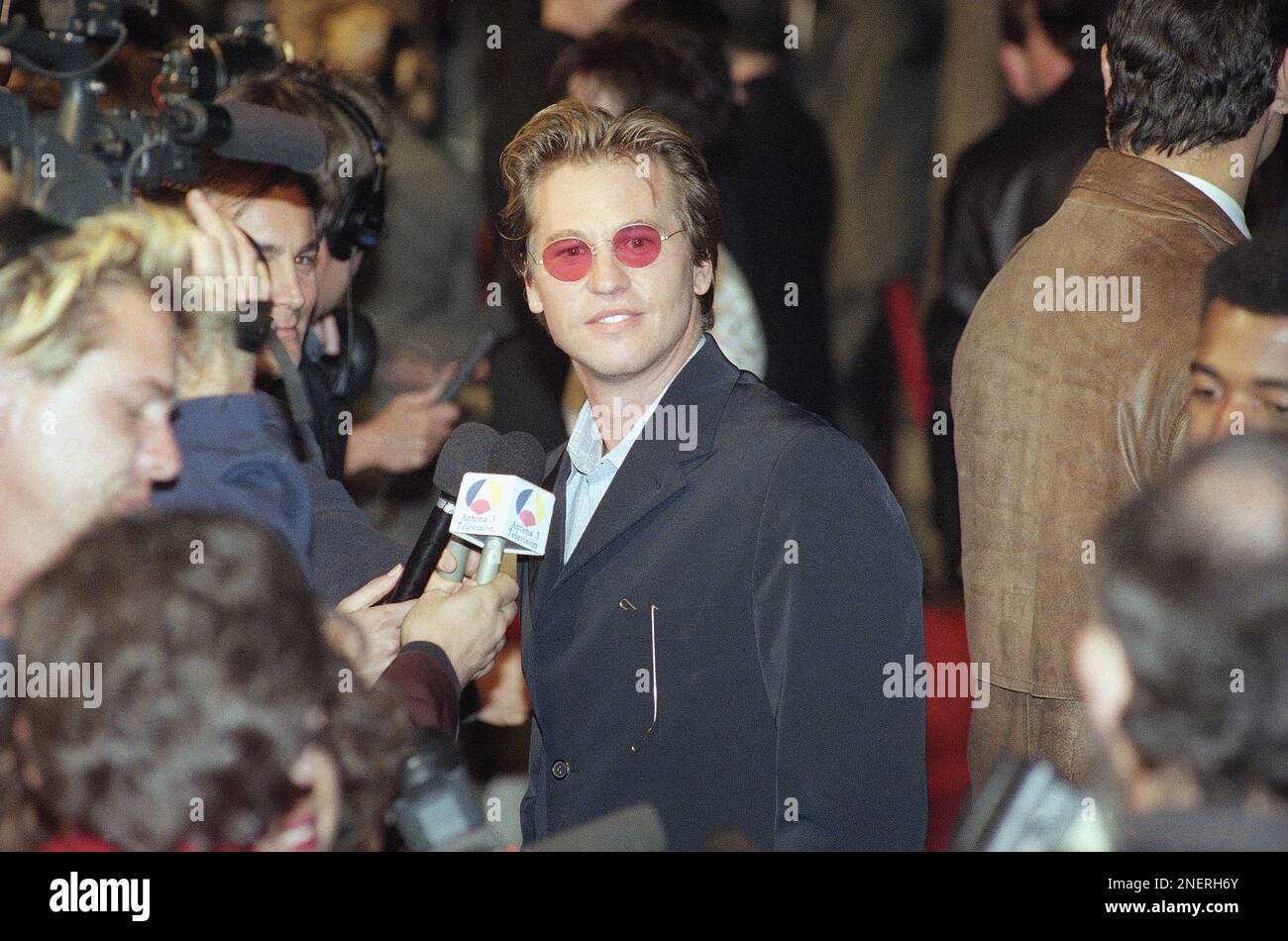 Actor Val Kilmer, star of the new film ?The Saint,? peers over in the direction of screaming fans as he is interviewed at the premiere of the film, Thursday, April 3, 1997 at the Academy of Motion Picture Arts & Sciences in Beverly Hills, California. (AP Photo/Chris Pizzello) Stockfoto