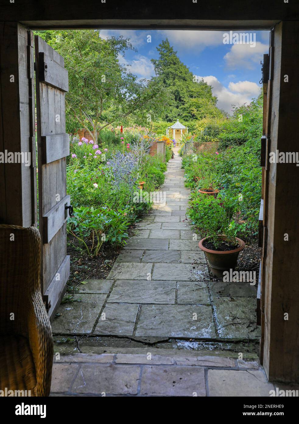 Ein Blick durch eine alte hölzerne Tür im Wollerton Old Hall Gardens Garten Wollerton Market Drayton Shropshire England UK Stockfoto