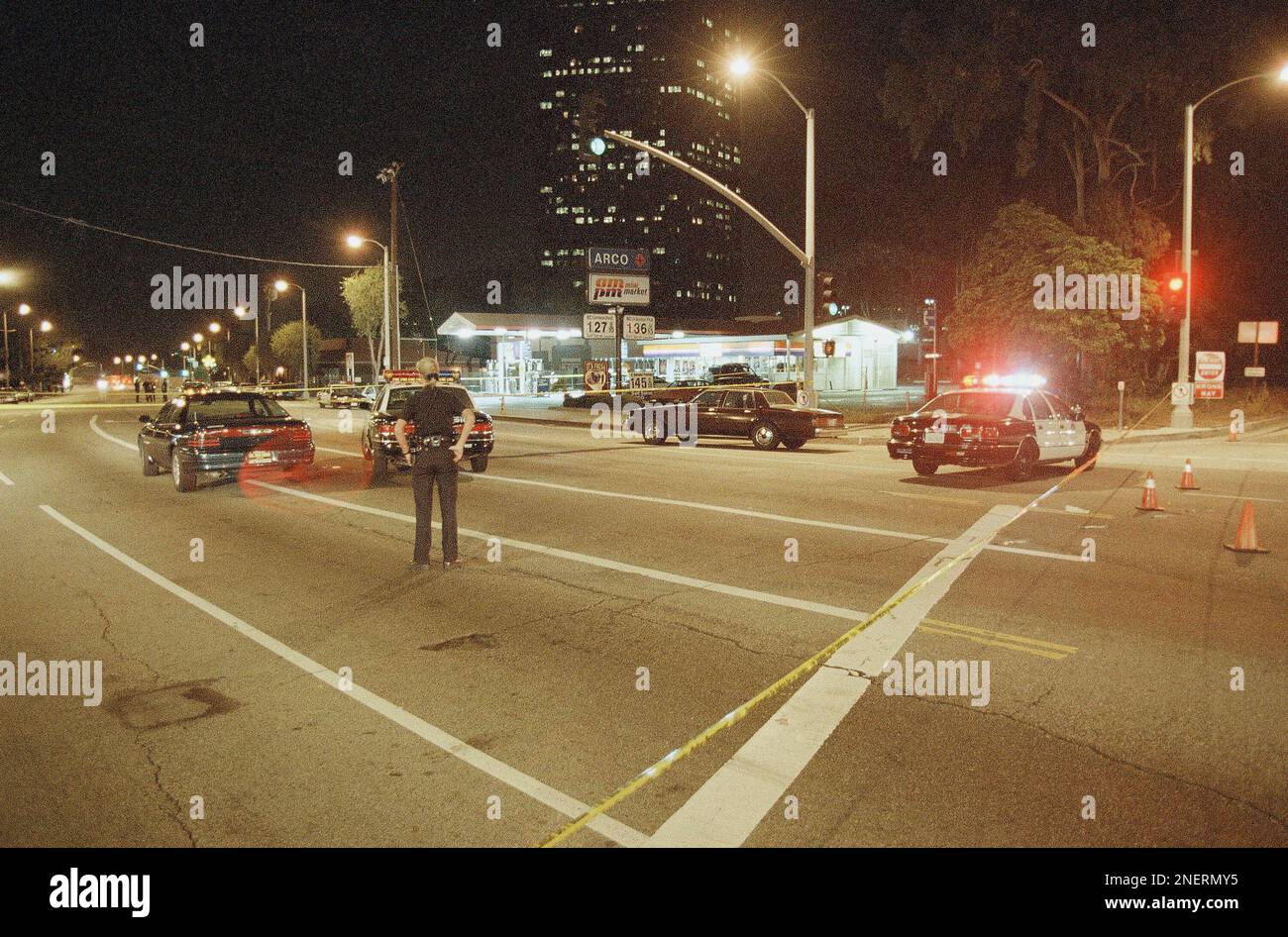 A Los Angeles police officer stands in the middle of a closed down ...