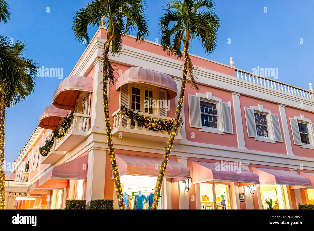 Naples, USA - 23. Dezember 2021: Altstadt von Naples, Einkaufsviertel Third Street South in Florida, rosafarbenes Gebäude für Marissa-Boutique bei Nacht, Weihnachten Stockfoto