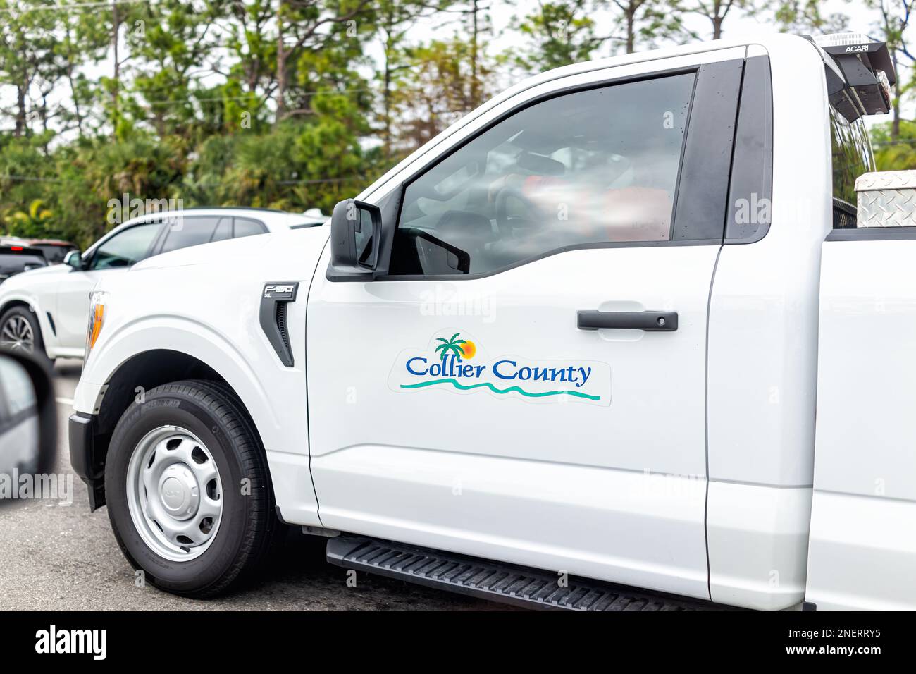 Naples, USA - 28. Januar 2022: Abholschild der kommunalen Regierung von Collier County, Lkw-Fahrt auf der Autobahn im Südwesten Floridas in Downtown tr Stockfoto