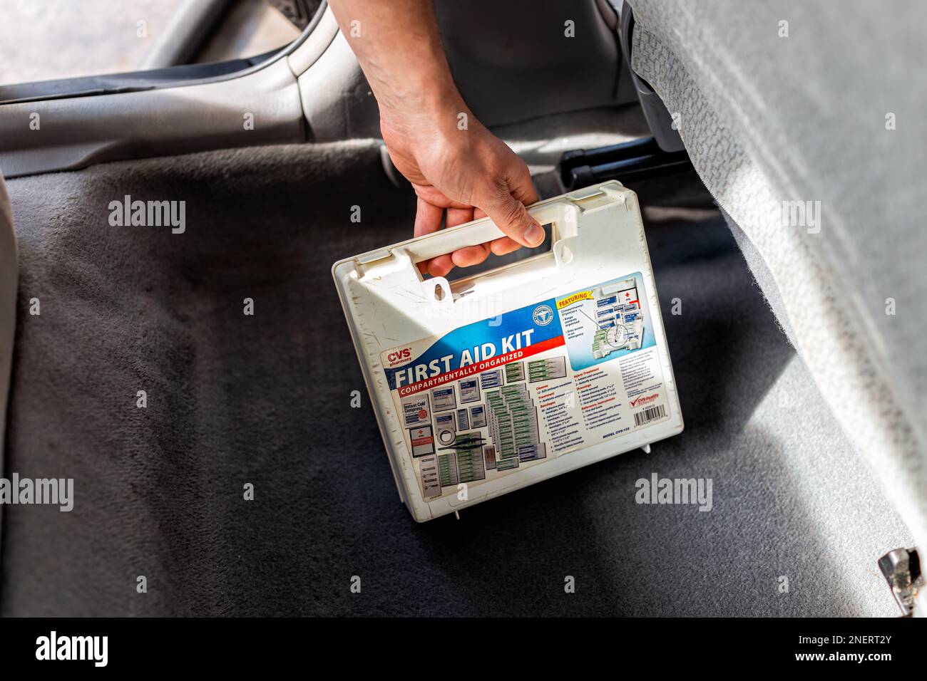 Neapel, USA - 11. Februar 2022: Erste-Hilfe-Kasten, Hand-Halten medizinische Versorgung im Auto Innenraum am Fahrzeugsitz für Reise-Notfallversorgung Stockfoto