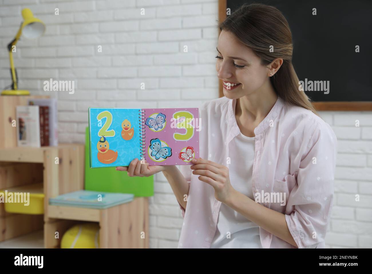 Glückliche Englischlehrerin, die in der Grundschule Unterricht gibt Stockfoto