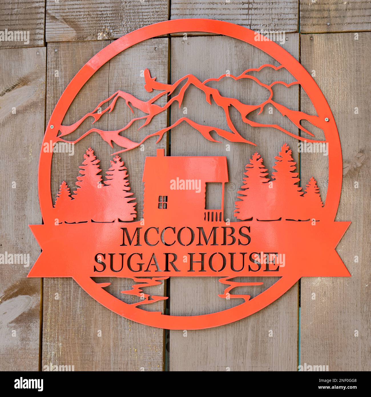Ein leuchtend orangefarbenes Metallschild auf dem McCombs Ahornsirup Zuckerhaus in den Adirondack Mountains, NY, USA Stockfoto