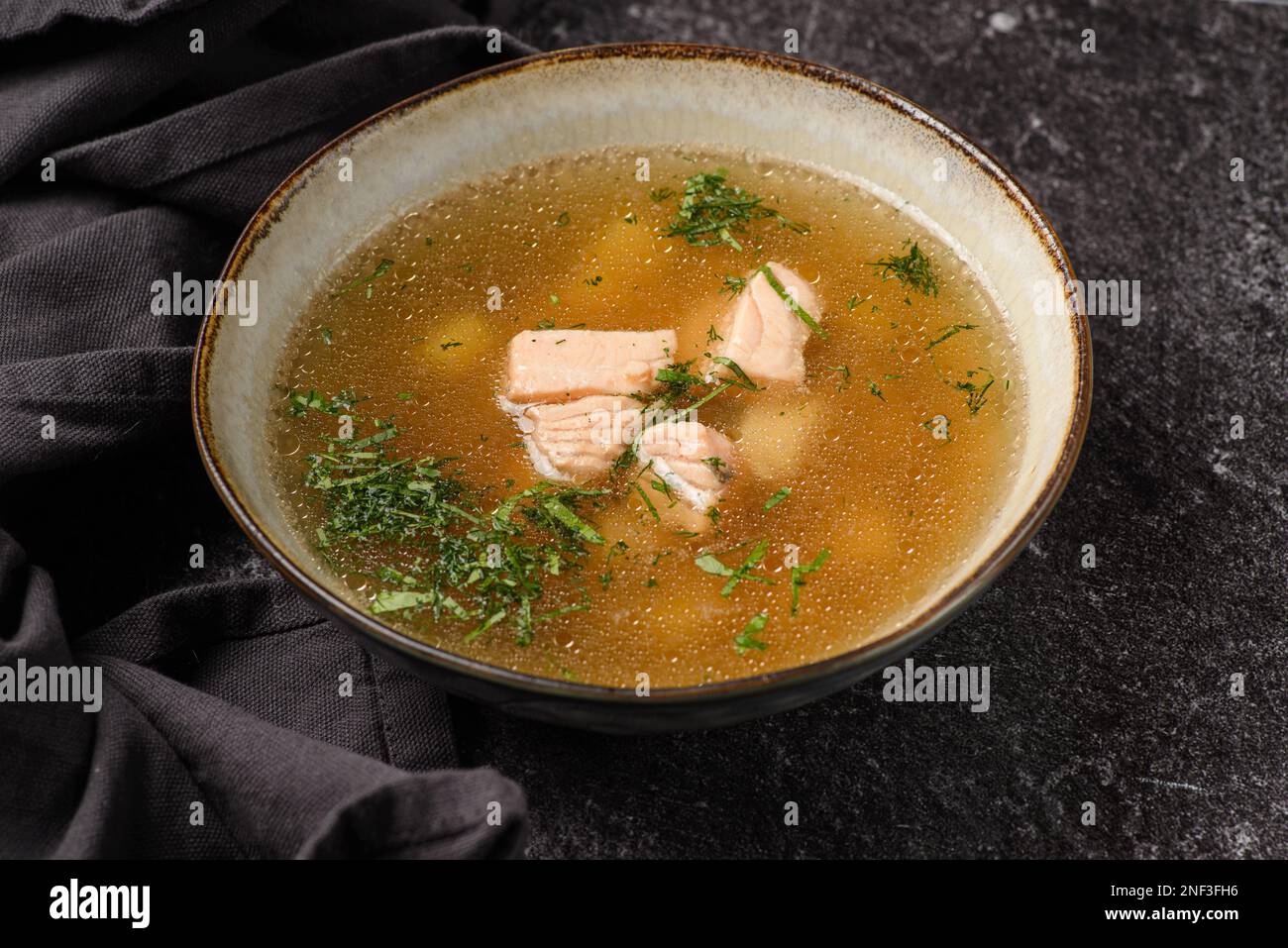 Fischsuppe mit Lachs auf dunklem Hintergrund. Hochwertiges Foto Stockfoto