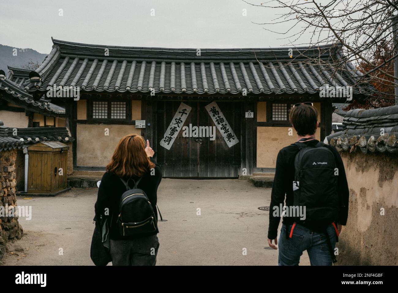 Ein Reisender und ein Einheimischer erkunden ein altes Gebäude im Hahoe Folk Village in Andong, Südkorea. Stockfoto