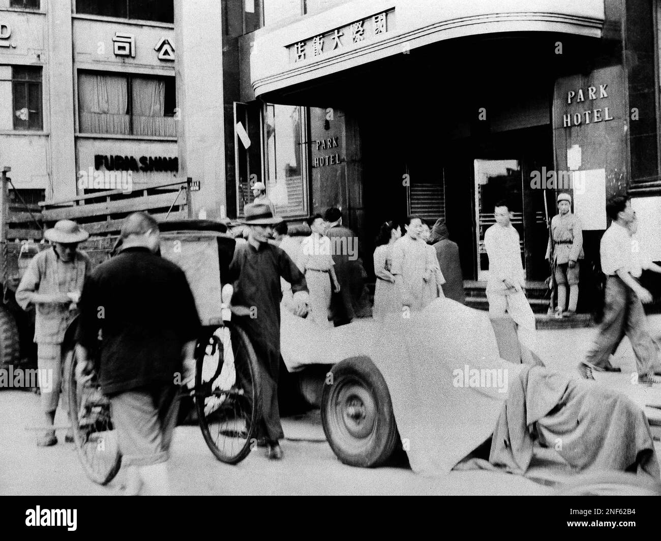 This is a Communist artillery piece, covered, parked outside Park Hotel, in Shanghai, China, May 27, 1949. Outside the hotel are two Red sentries. This American-made artillery was captured from the Nationalists by the Communists. (AP Photo) Stockfoto
