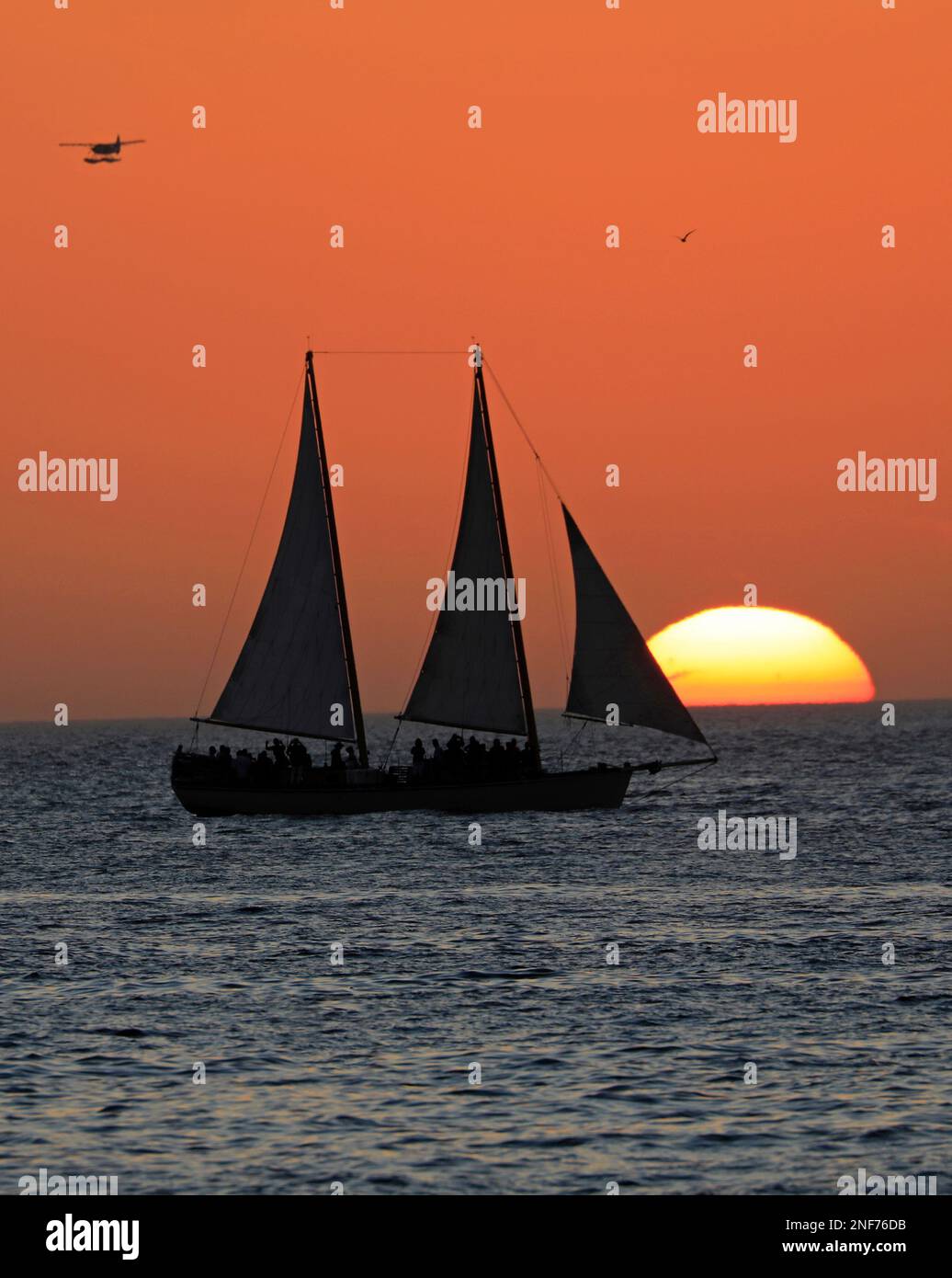 Key West Sonnenuntergang, Golf von Mexiko mit Sonne und Yacht im Hintergrund Stockfoto