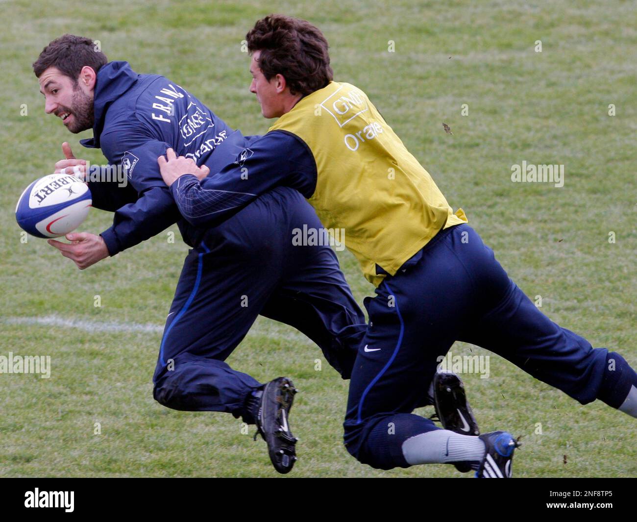 French rugby team player Julien Malzieu, left, is tackled by Yannick ...