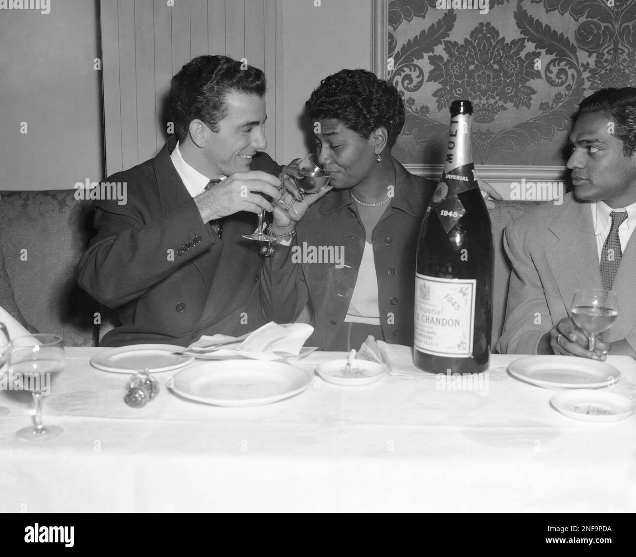 American swing drummer, Louis Bellson, Jr., member of Duke Ellington's band, was married to blues singer, Pearl Bailey at London's Caxton Hall, in England, Nov. 19, 1952. The couple sip champagne at their wedding reception at Siegi's Club on Charles Street, London. (AP Photo/Leslie Priest) Stockfoto