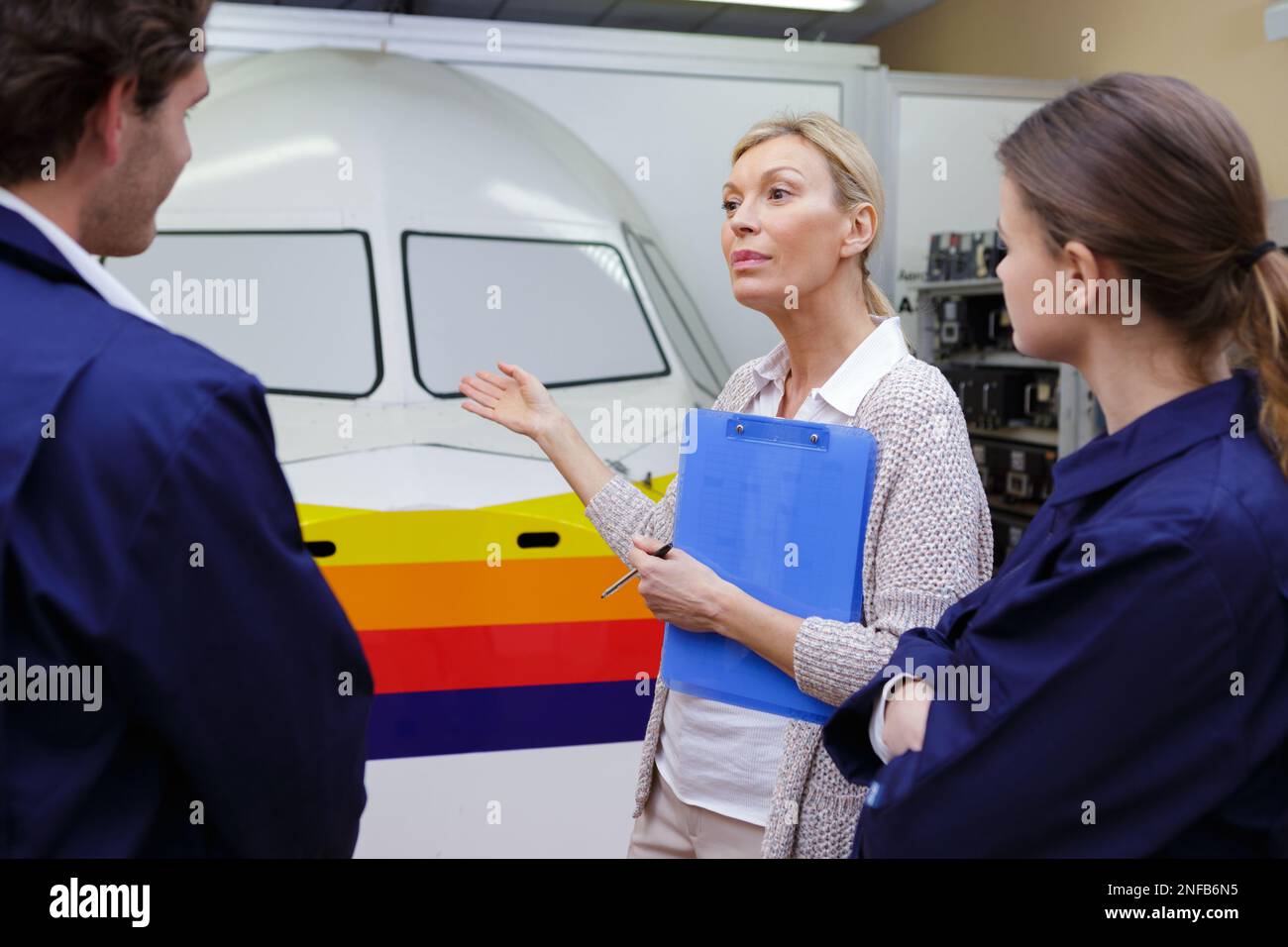 Pilotin im Retro-Flugzeug mit Lehrlingen Stockfoto