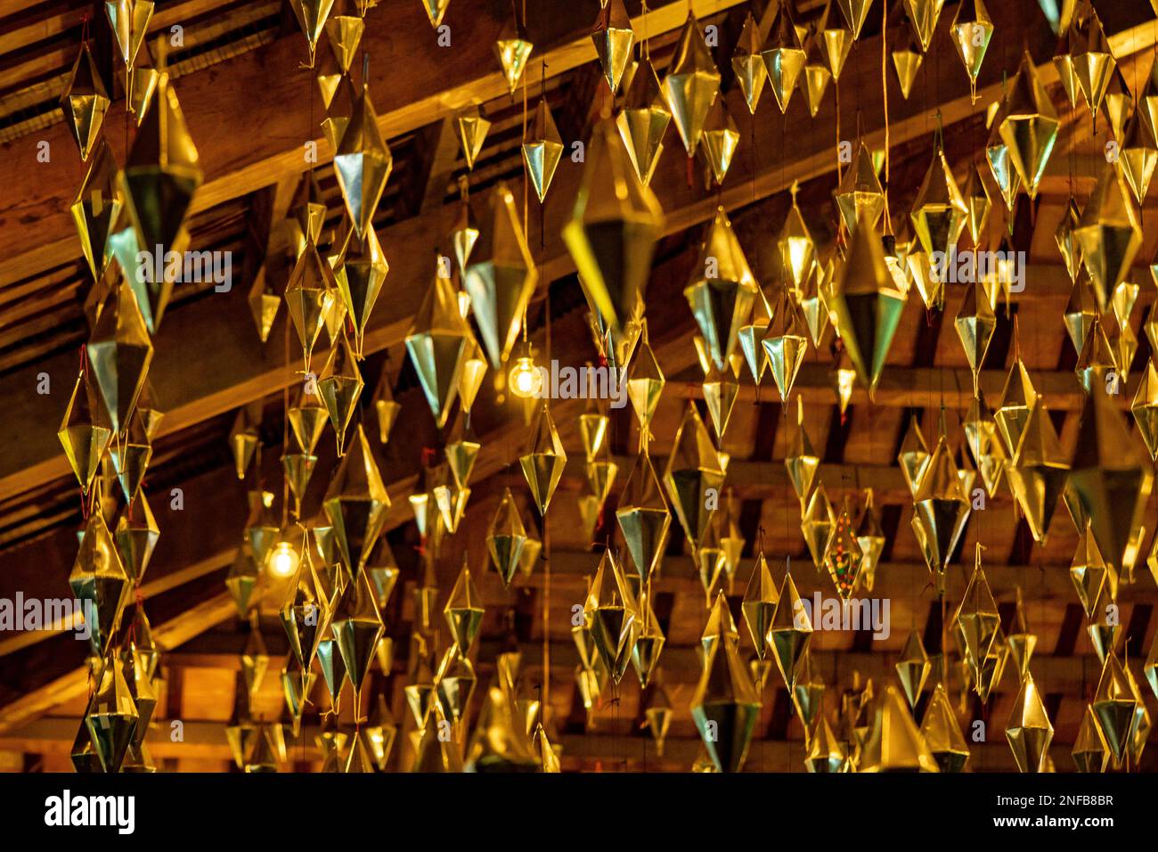 Diamanten oder goldene geometrische Formen, die von der Holzdecke der granollers Veranda hingen, folgten als Lampen Stockfoto