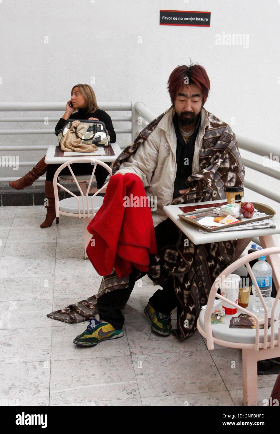 Hiroshi Nohara, of Japan, right, looks at donated food in Mexico City's