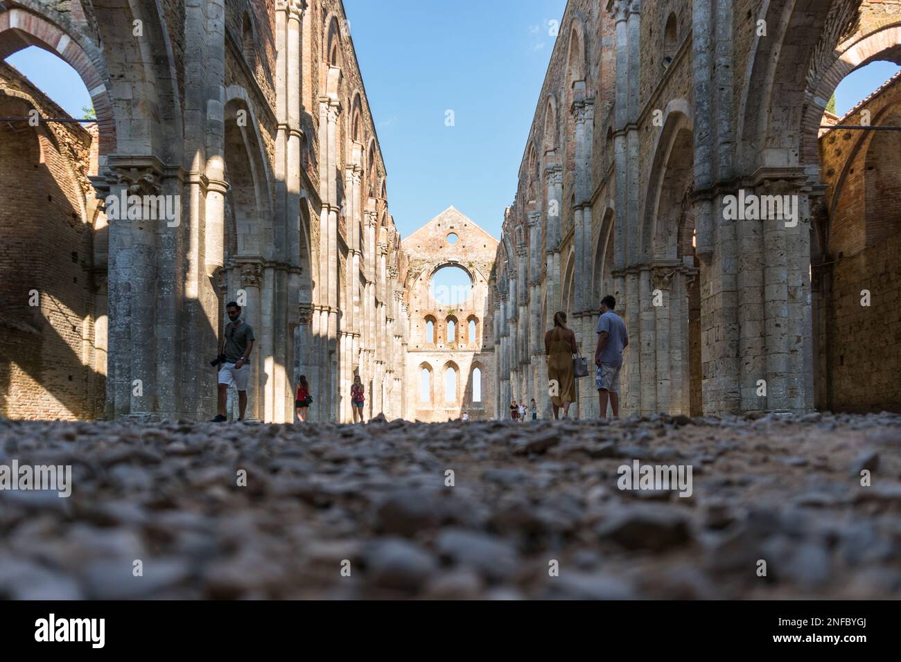 San Galgano, Italien-august 8,2020: Touristen besuchen das Innere der Abtei und das ehemalige Kloster von San Galgano, berühmt für seine Dachlosigkeit während der Sonne Stockfoto