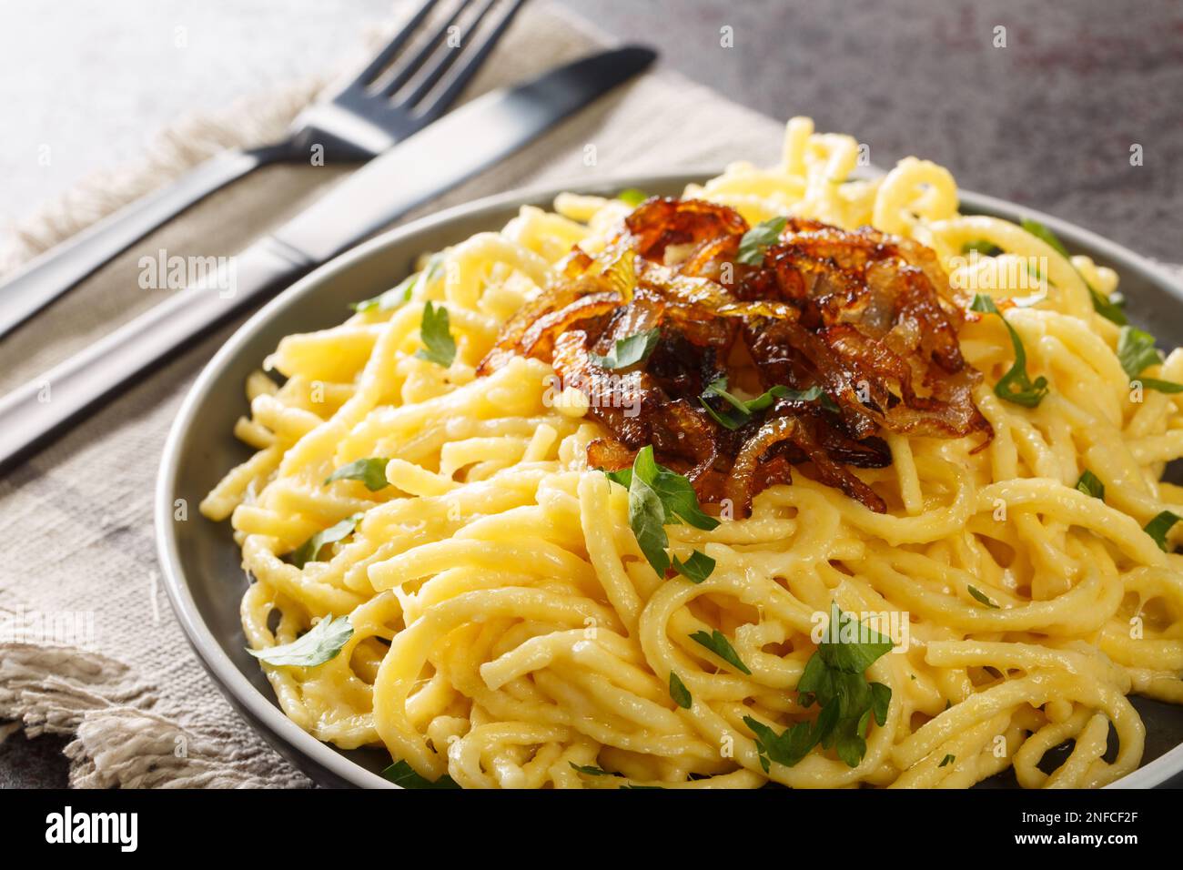 Kasespatzle leckere Nudeln mit Käse und gebratenen Zwiebeln aus nächster Nähe auf einem Teller