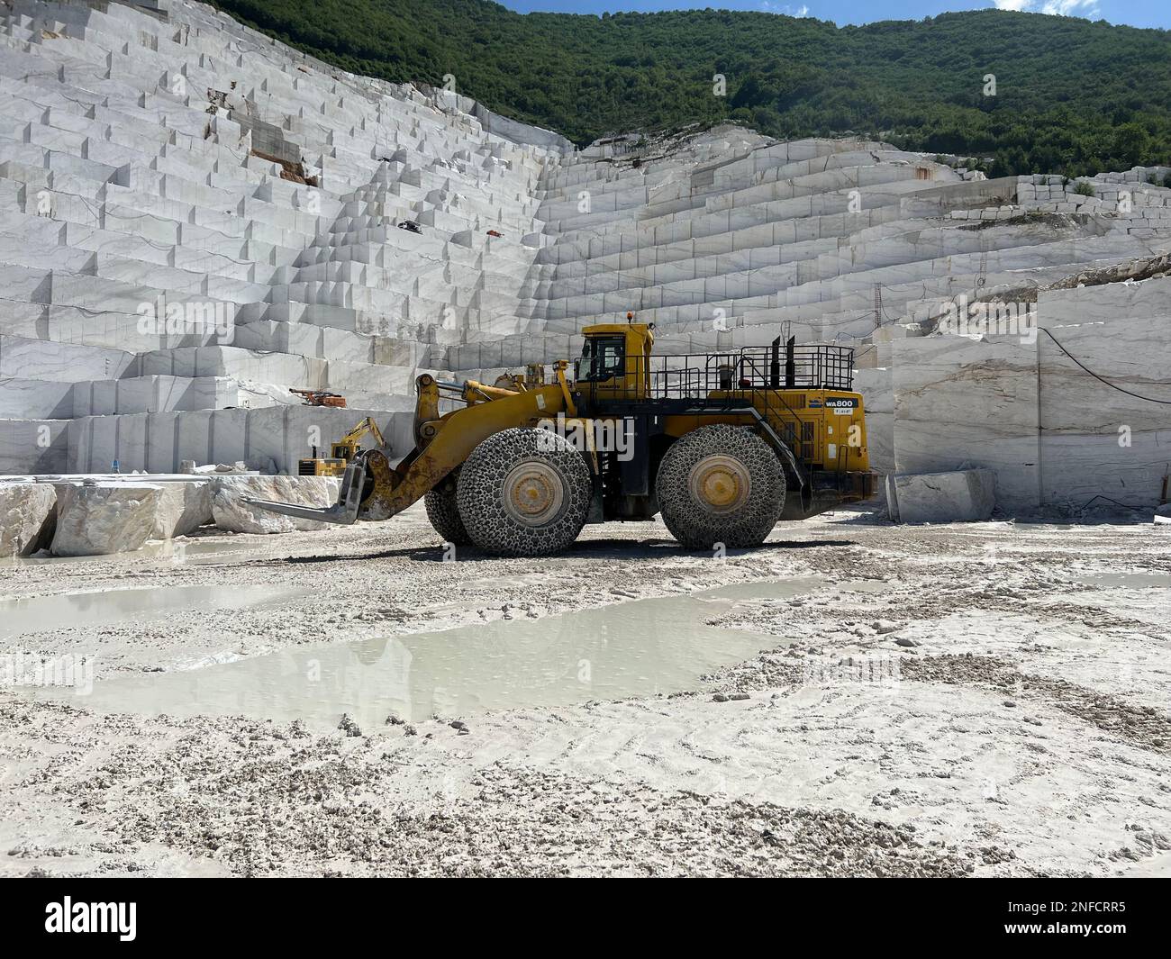 Radlader in einem riesigen Marmorbruch in Europa. Wir transportieren die Marmorblöcke. Stockfoto