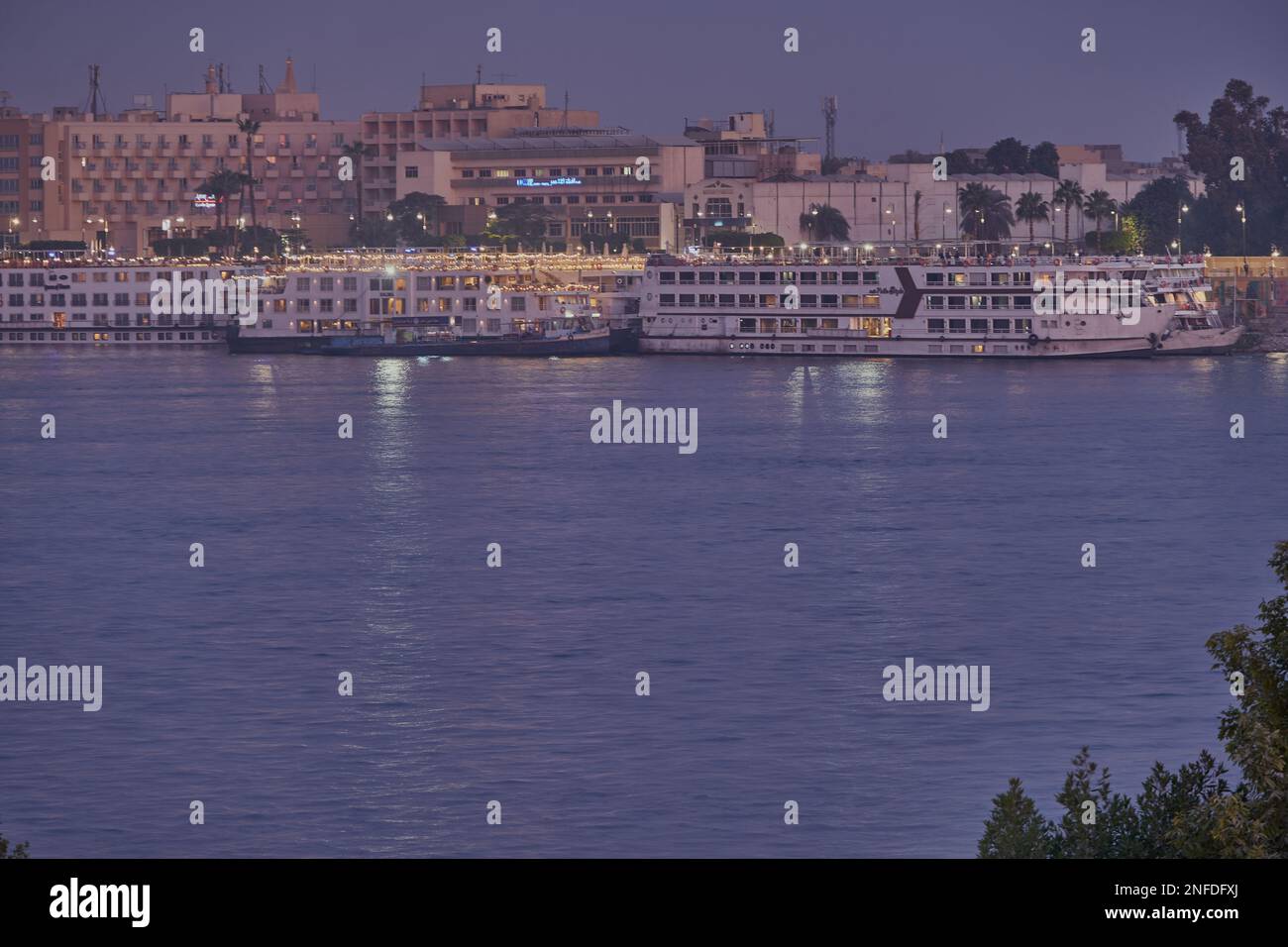 Luxor, Ägypten Nachtaufnahme vom Westufer aus, der den Nil mit Felukken und Kreuzfahrtschiffen zeigt Stockfoto