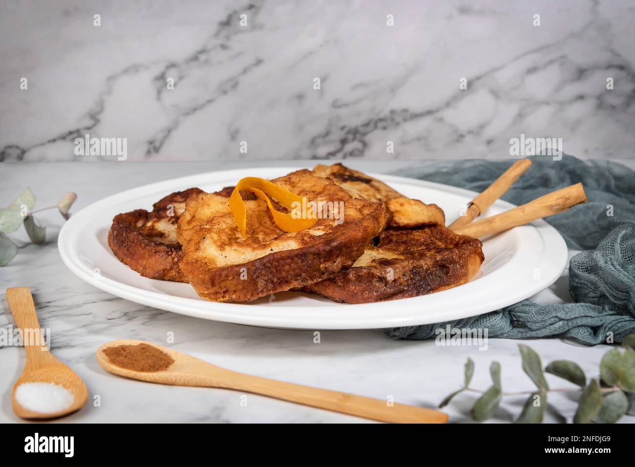 Torrijas auf einer Marmorarbeitsfläche. Typisch spanische Süßigkeiten aus Brot, Milch, Eiern, Zucker und Zimt, die während des Karnevals und Ostern konsumiert wurden Stockfoto