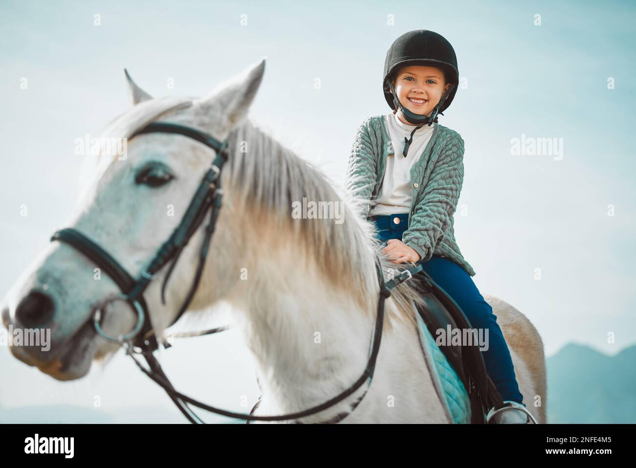 Ranch, glücklich und Mädchen auf einem Pferd, um das Reiten für eine Meisterschaft, einen Wettkampf oder ein Rennen zu üben. Glück, Tier und Kind mit Lächeln, die es üben Stockfoto