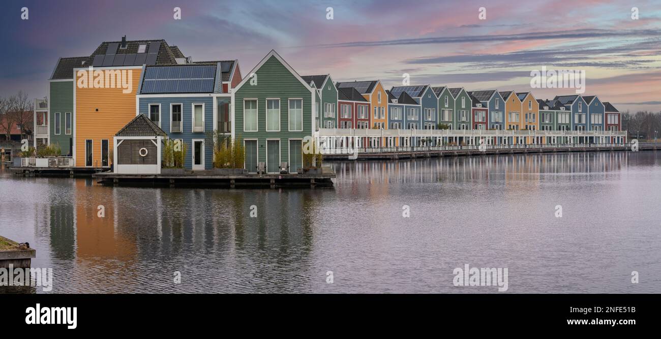 Panoramablick auf berühmte farbenfrohe Holzhäuser am Rietplas-See in Houten, Provinz Utrecht, Niederlande, bei Sonnenaufgang Stockfoto