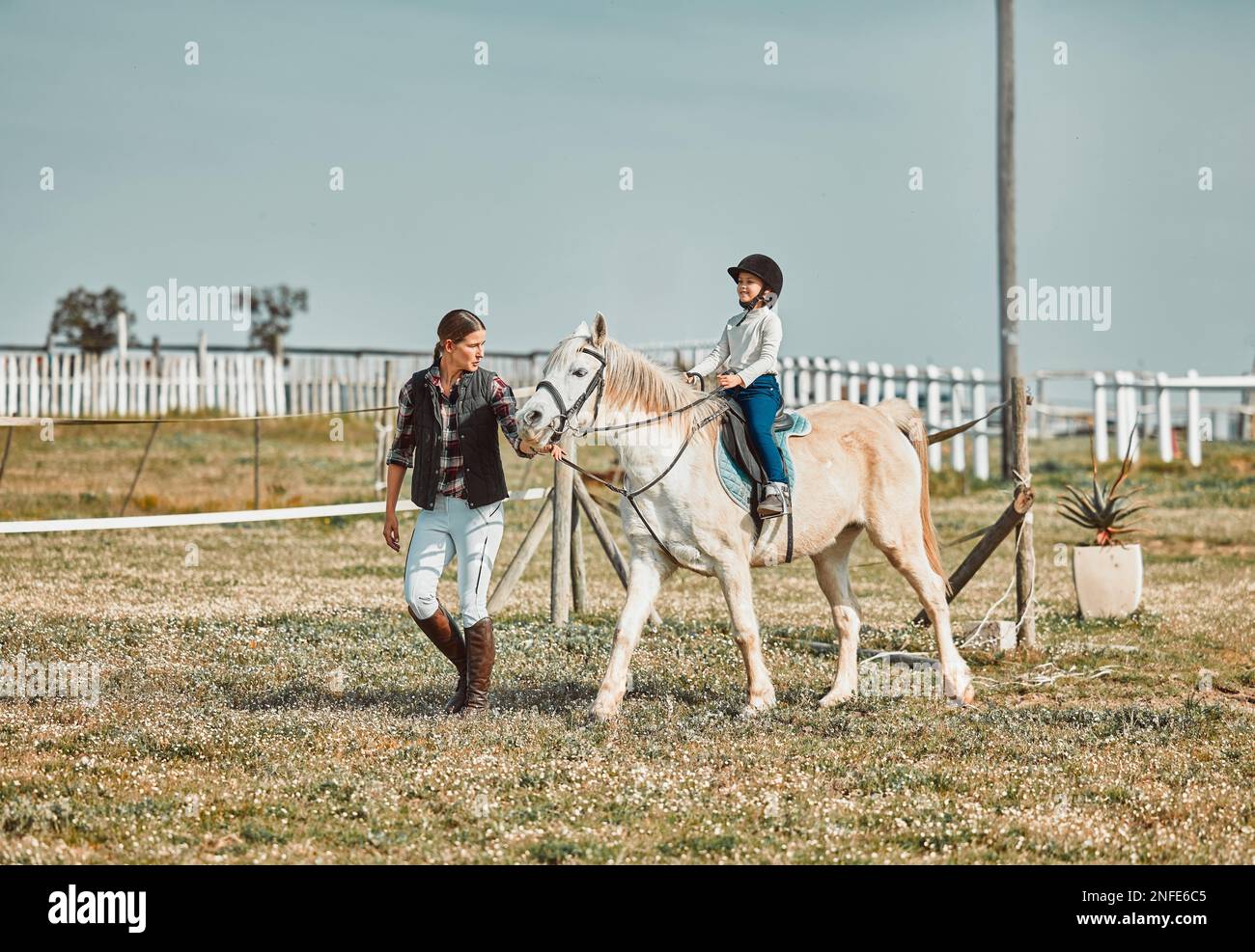 Unterricht, Hilfe und Frau mit einem Kind auf einem Pferd zum Lernen, Sport und Hobby auf einem Bauernhof in Italien. Helfen, unterstützen und coachen Sie ein Mädchen Stockfoto