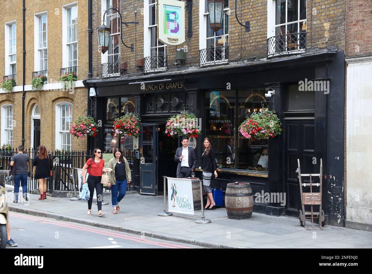 LONDON, Großbritannien - 8. JULI 2016: Besucher besuchen den Pub „Bunch of Grapes“ von Young's Pub in Southwark Borough in London, Großbritannien. Es gibt mehr als 7.000 Pubs in Stockfoto