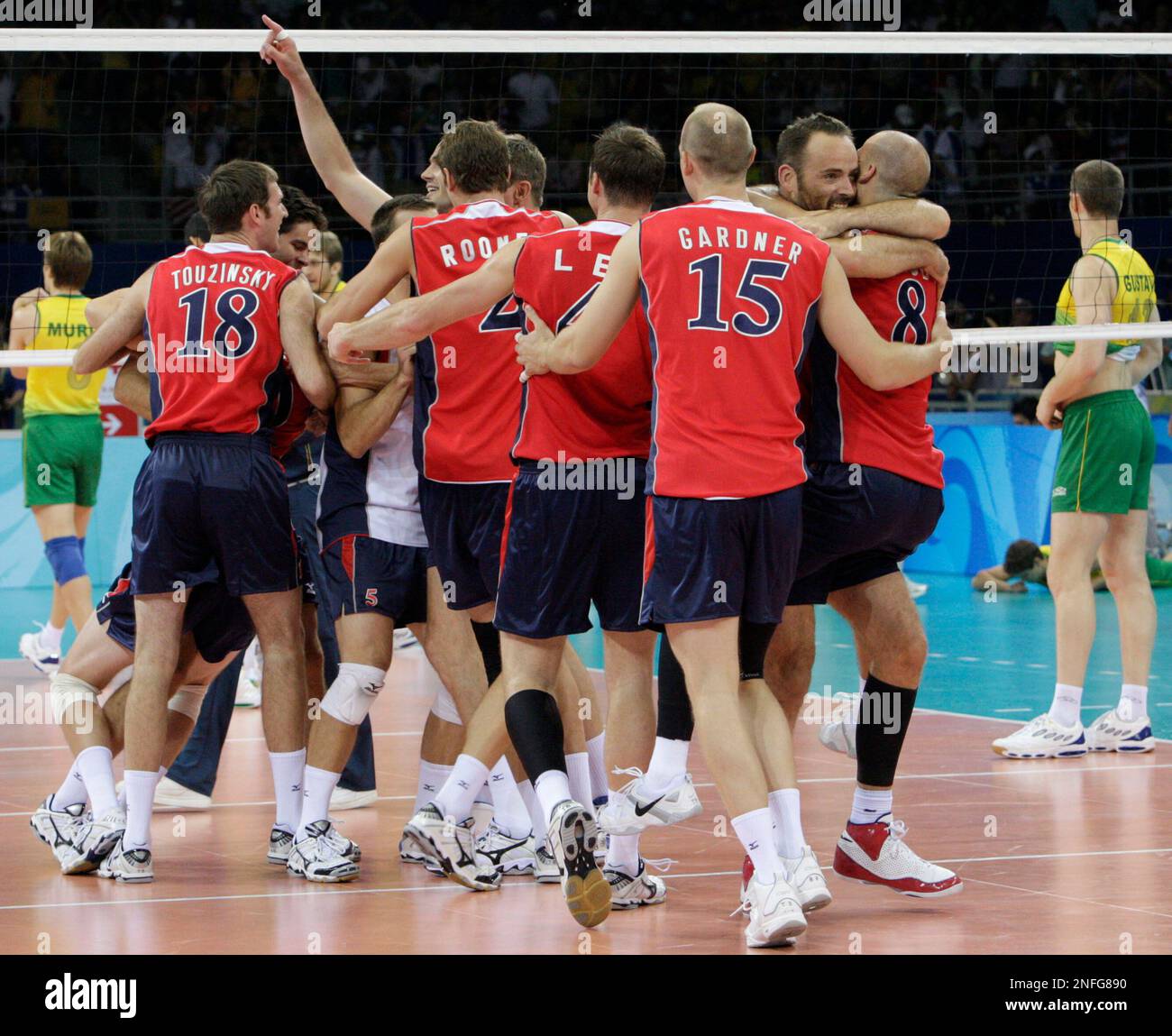USA's players, from left, Scott Touzinsky (18), Sean Rooney, David Lee, Gabriel Gardner (15) and William Priddy (8), celebrate with other teammates after defeating Brazil in their men's volleyball gold medal match at the Beijing 2008 Olympics in Beijing, Sunday, Aug. 24, 2008. USA won the gold and Brazil took silver. (AP Photo/Andy Wong) Stockfoto