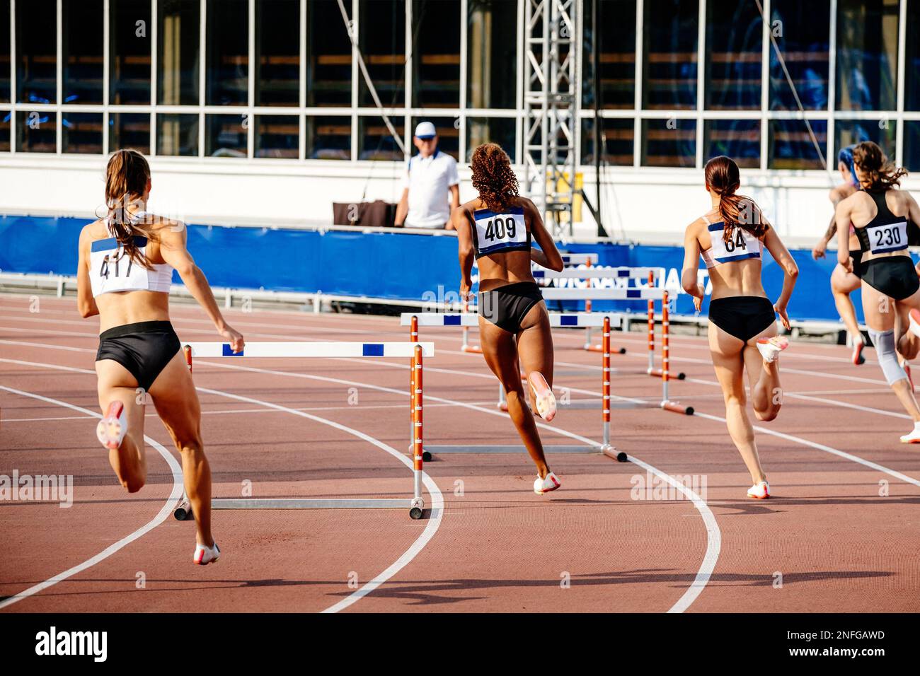 Frauen laufen 400 Meter Hürden in einem sportlichen Wettkampf Stockfoto