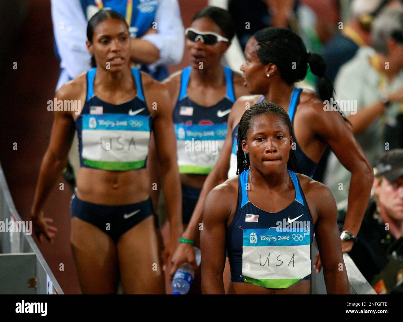 United States' Torri Edwards, Angela Williams, Mechelle Lewis and Lauryn Williams, from left, leave the stadium after dropping the baton in the women's 4x100-meter relay during the athletics competitions in the National Stadium at the Beijing 2008 Olympics in Beijing, Thursday, Aug. 21, 2008. (AP Photo/Kevin Frayer) Stockfoto