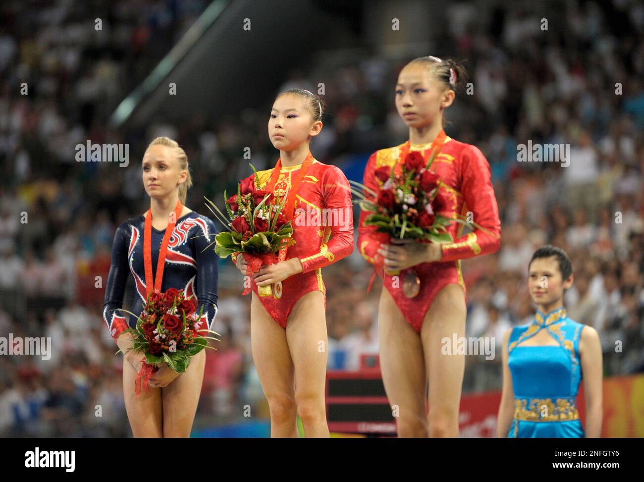 China's gymnast gold medal winner He Kexin, center, is flanked by ...