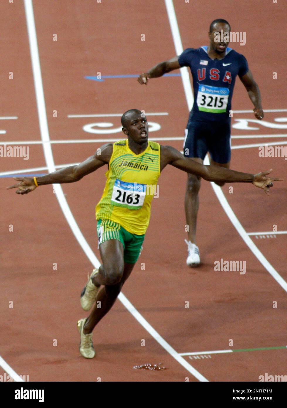 Jamaica's Usain Bolt, front, crosses the finish line to win gold in the men's 100-meter final during the athletics competitions in the National Stadium at the Beijing 2008 Olympics in Beijing, Saturday, Aug. 16, 2008. (AP Photo/Greg Baker) Stockfoto