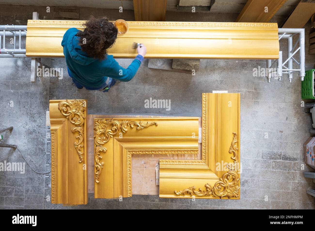 Dresden, Deutschland. 17. Februar 2023. Anne Rauschenberg, Theaterbildhauerin, arbeitet an einem goldenen Rahmen in einer Werkstatt. Der mit Stuckverzierungen und Verzierungen dekorierte Rahmen ist Teil der Blumenshow „Dresden Spring“, die vom 03. Bis 12. März 2023 im Barockpalast im Großen Garten stattfindet. Kredit: Sebastian Kahnert/dpa/ZB/dpa/Alamy Live News Stockfoto