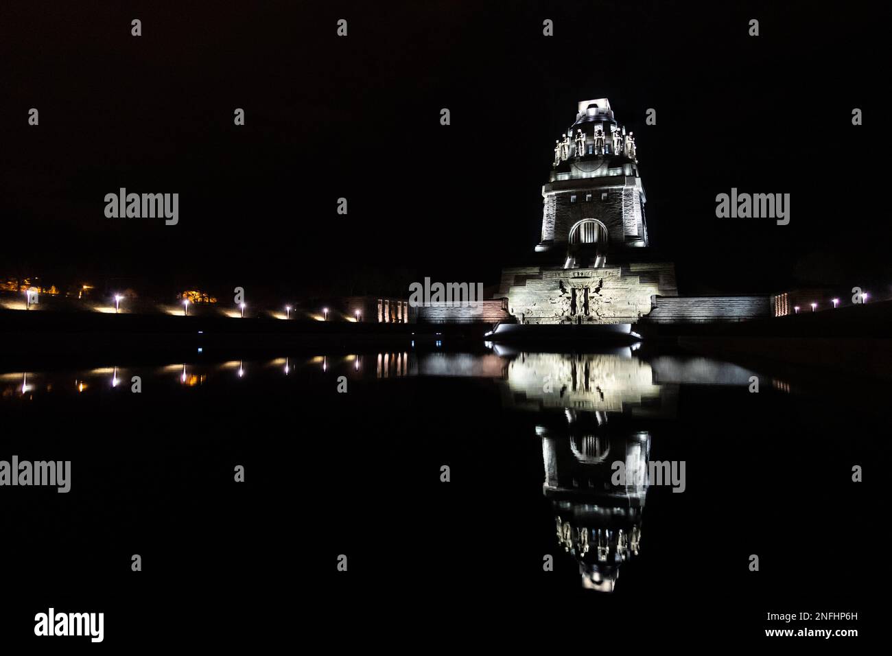 Nachtaufnahme des Denkmals für die Schlacht der Nationen 1813 in Leipzig, Reflexion über das Wasser, symmetrische Perspektive, Wahrzeichen und Gedenkfeier Stockfoto