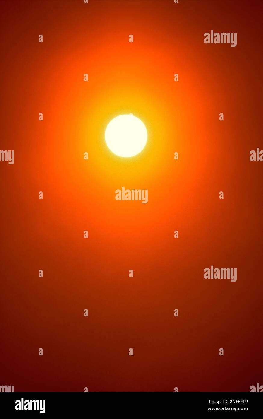 Goldene Sommersonne hoch am Himmel um 12:00 Uhr mittags. Vollformat-Nahaufnahme. Große Disc allein mit langem Teleobjektiv. Stockfoto