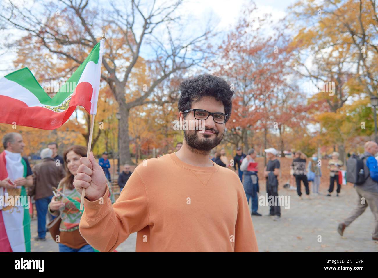 Toronto Ontario, Kanada - 5. November 2022: Ein schwuler Iraner, der bei einem Protest gegen den Iran mit der iranischen Flagge wedelt Stockfoto