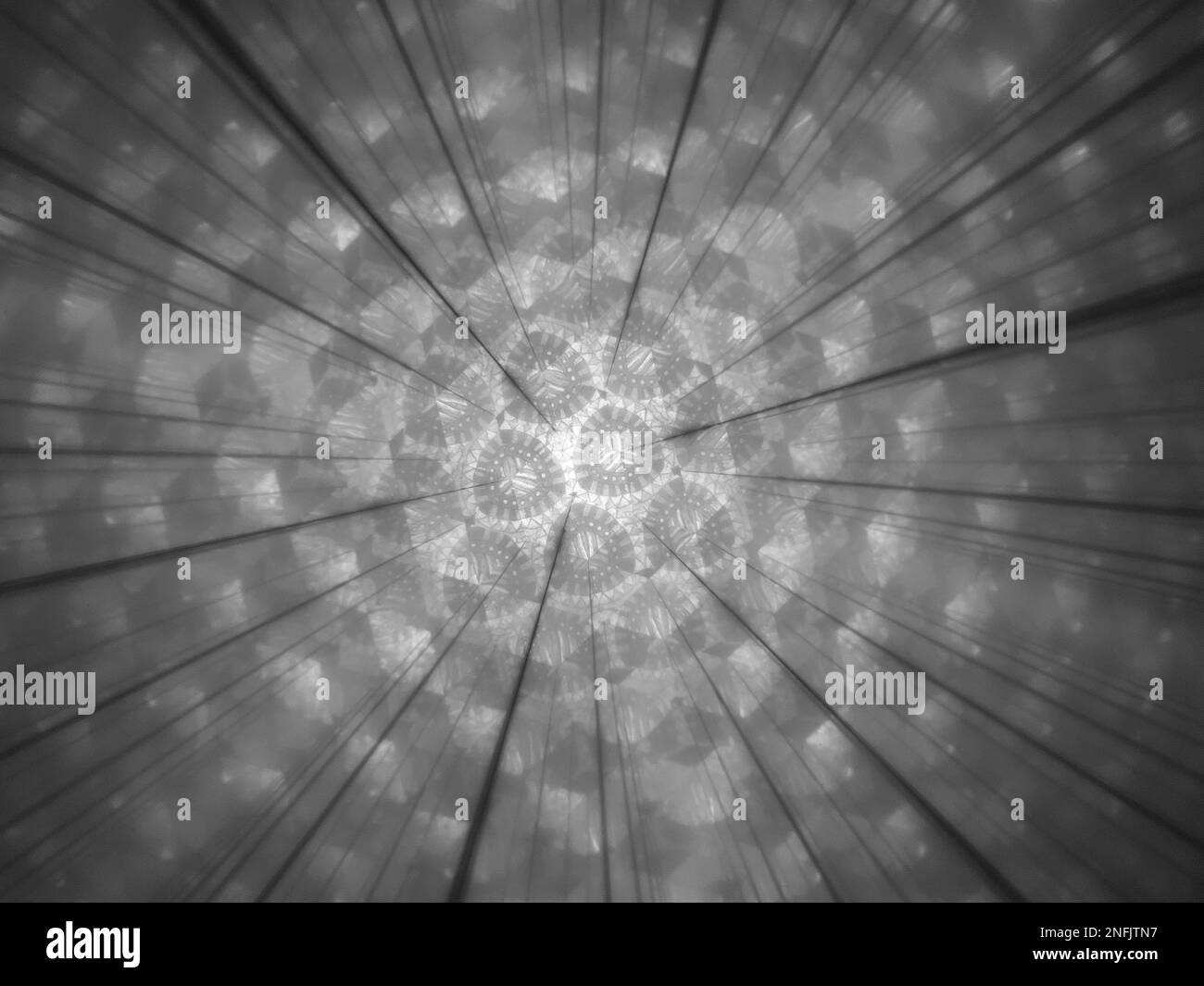 Nahaufnahme durch Kaleidoskop in Schwarz und Weiß mit lustigem Muster Stockfoto