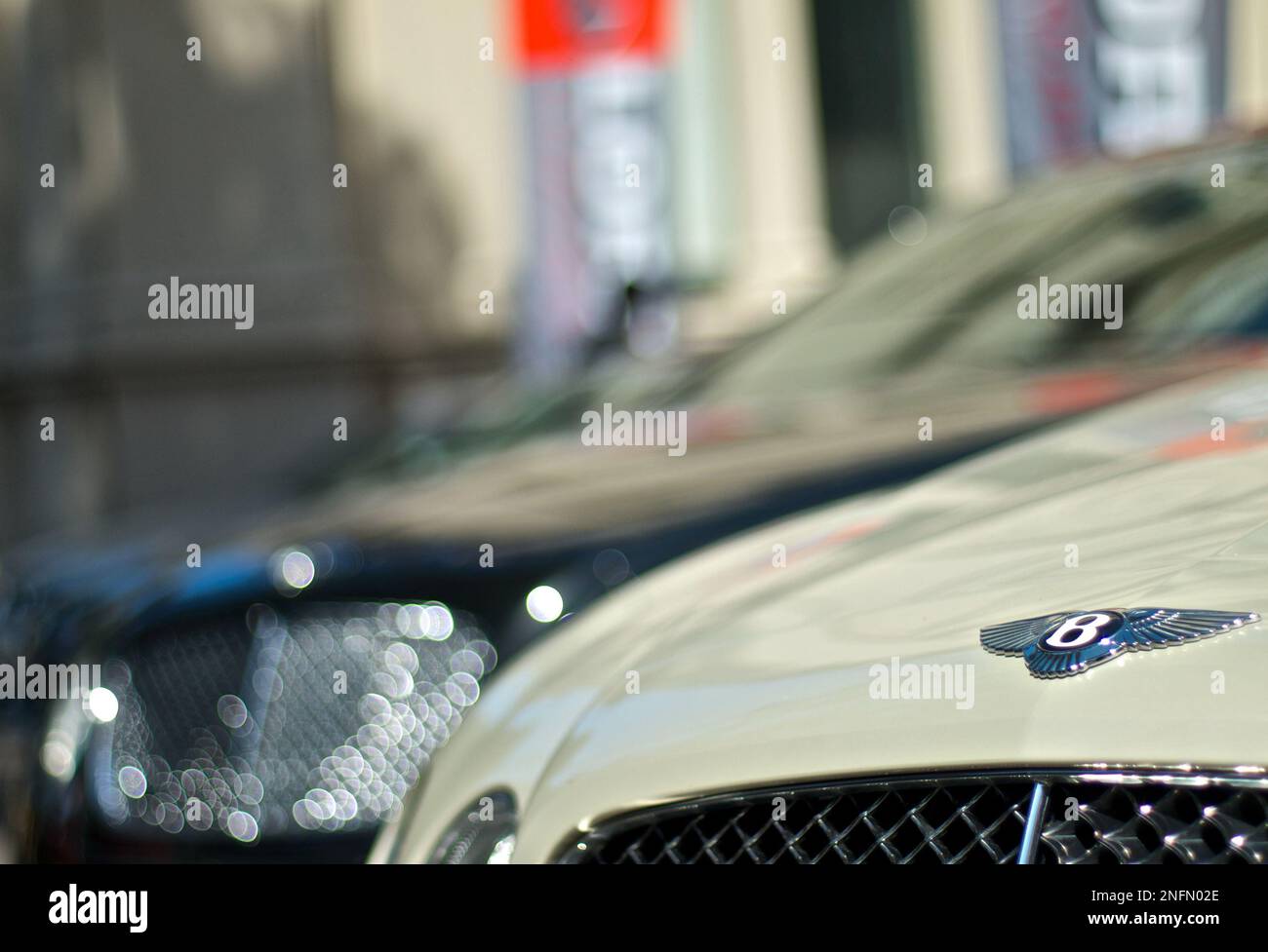 Silbernes Bentley Motorhaubenlogo in schwarzem Bentley Bokeh Hintergrund für Tiefenschärfe Stockfoto